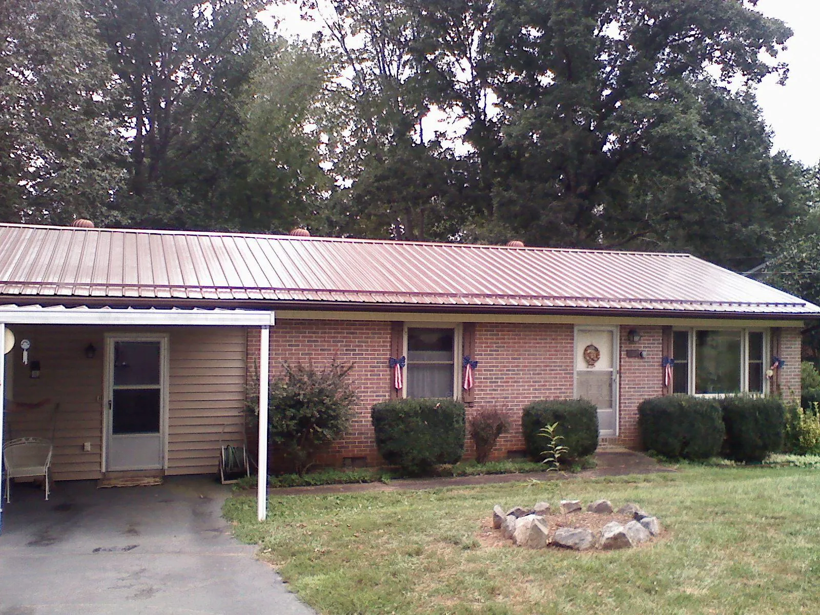 Bronze metal roof and carport on a brick ranch home — Roof Repair work by our crew in Bealeton